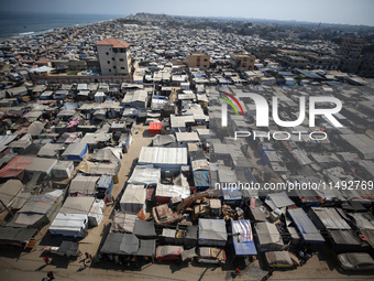 Displaced Palestinians, who are fleeing their house due to Israeli strikes, are sheltering at a tent camp amid the ongoing conflict between...