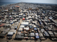 Displaced Palestinians, who are fleeing their house due to Israeli strikes, are sheltering at a tent camp amid the ongoing conflict between...