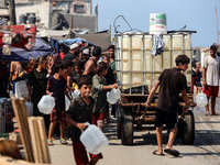 Palestinian displaced people are trying to fill containers with water in Deir el-Balah, Gaza Strip, on August 19, 2024, amid the ongoing con...