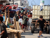 Palestinian displaced people are trying to fill containers with water in Deir el-Balah, Gaza Strip, on August 19, 2024, amid the ongoing con...