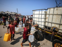 Palestinian displaced people are trying to fill containers with water in Deir el-Balah, Gaza Strip, on August 19, 2024, amid the ongoing con...