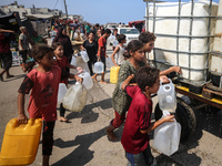 Palestinian displaced people are trying to fill containers with water in Deir el-Balah, Gaza Strip, on August 19, 2024, amid the ongoing con...