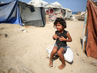 A displaced Palestinian girl is sitting beside the tents in Deir al-Balah in central Gaza Strip on August 19, 2024, amid the ongoing conflic...