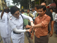 A Kolkata policewoman officer is tying a Rakhi, or a traditional Indian sacred thread, on the wrist of a doctor at a protest rally for the R...