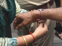 A doctor is tying Rakhis, or a traditional Indian sacred thread, on the wrist of a Kolkata Police officer during a protest rally for the R G...