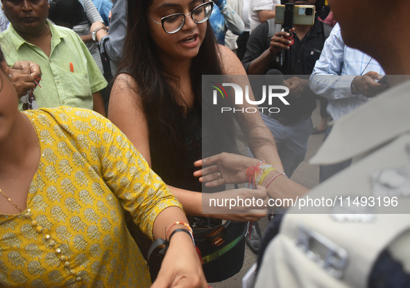 A doctor is tying Rakhis, or a traditional Indian sacred thread, on the wrist of a Kolkata Police officer during a protest rally for the R G...