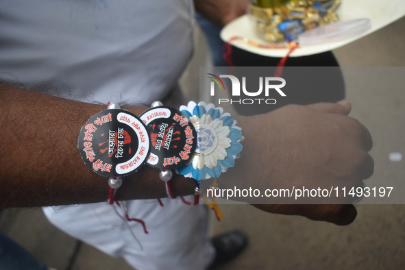 A Kolkata police officer is tying Rakhis, or a traditional Indian sacred thread, on the wrist during a protest rally for the R G Kar medical...