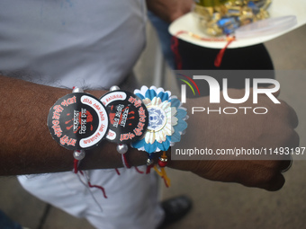 A Kolkata police officer is tying Rakhis, or a traditional Indian sacred thread, on the wrist during a protest rally for the R G Kar medical...