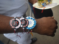 A Kolkata police officer is tying Rakhis, or a traditional Indian sacred thread, on the wrist during a protest rally for the R G Kar medical...