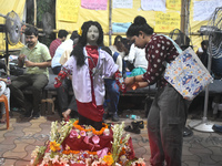 A doctor is tying Rakhis, or a traditional Indian sacred thread, on the wrist of a clay statue of a female doctor depicting a victim of rape...