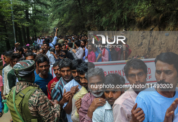 An Indian Paramilitary soldier is standing guard as Hindu devotees are arriving to pay obeisance on the occasion of the Raksha Bandhan festi...