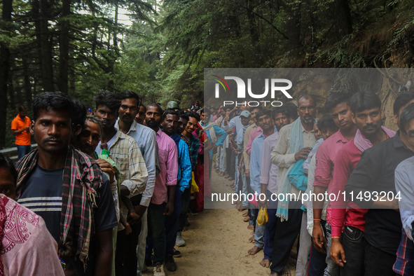 Hindu devotees are waiting in a long queue to pay their obeisance on the occasion of the Raksha Bandhan festival at the Shankaracharya templ...