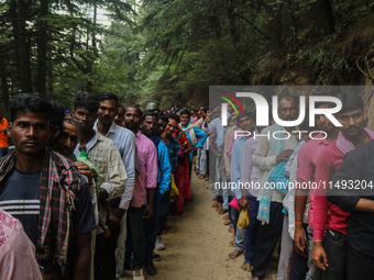 Hindu devotees are waiting in a long queue to pay their obeisance on the occasion of the Raksha Bandhan festival at the Shankaracharya templ...