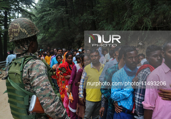 An Indian Paramilitary soldier is standing guard as Hindu devotees are arriving to pay obeisance on the occasion of the Raksha Bandhan festi...