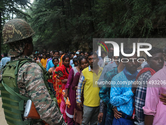 An Indian Paramilitary soldier is standing guard as Hindu devotees are arriving to pay obeisance on the occasion of the Raksha Bandhan festi...