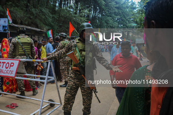 An Indian Paramilitary soldier is gesturing as Hindu devotees are arriving to pay obeisance on the occasion of the Raksha Bandhan festival a...