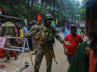 An Indian Paramilitary soldier is gesturing as Hindu devotees are arriving to pay obeisance on the occasion of the Raksha Bandhan festival a...