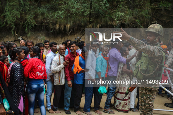 An Indian Paramilitary soldier is standing guard as Hindu devotees are arriving to pay obeisance on the occasion of the Raksha Bandhan festi...