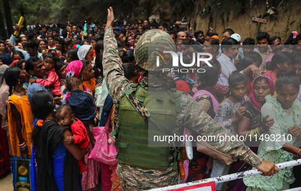 An Indian Paramilitary soldier is standing guard as Hindu devotees are arriving to pay obeisance on the occasion of the Raksha Bandhan festi...