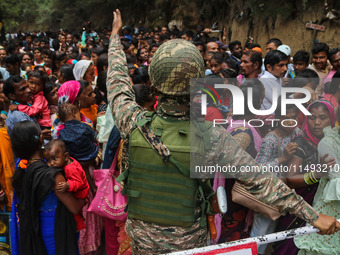 An Indian Paramilitary soldier is standing guard as Hindu devotees are arriving to pay obeisance on the occasion of the Raksha Bandhan festi...