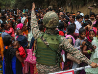 An Indian Paramilitary soldier is standing guard as Hindu devotees are arriving to pay obeisance on the occasion of the Raksha Bandhan festi...