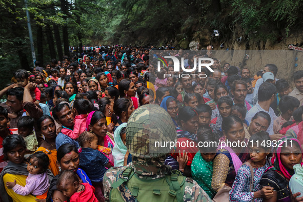 An Indian Paramilitary soldier is standing guard as Hindu devotees are arriving to pay obeisance on the occasion of the Raksha Bandhan festi...