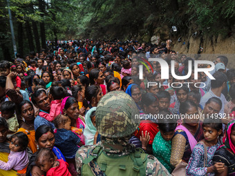 An Indian Paramilitary soldier is standing guard as Hindu devotees are arriving to pay obeisance on the occasion of the Raksha Bandhan festi...