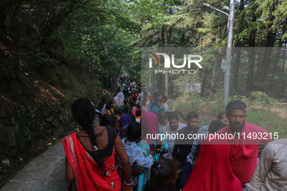 Hindu devotees are waiting in a long queue to pay their obeisance on the occasion of the Raksha Bandhan festival at the Shankaracharya templ...