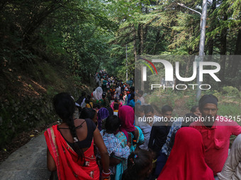 Hindu devotees are waiting in a long queue to pay their obeisance on the occasion of the Raksha Bandhan festival at the Shankaracharya templ...