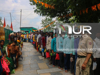 An Indian policeman is standing guard as Hindu devotees are arriving to pay obeisance on the occasion of the Raksha Bandhan festival at the...