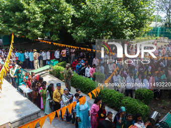 Hindu devotees are waiting in a long queue to pay their obeisance on the occasion of the Raksha Bandhan festival at the Shankaracharya templ...