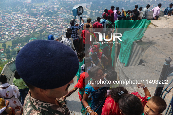 An Indian Paramilitary soldier is standing guard as Hindu devotees are arriving to pay obeisance on the occasion of the Raksha Bandhan festi...