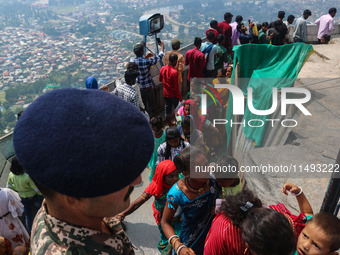 An Indian Paramilitary soldier is standing guard as Hindu devotees are arriving to pay obeisance on the occasion of the Raksha Bandhan festi...