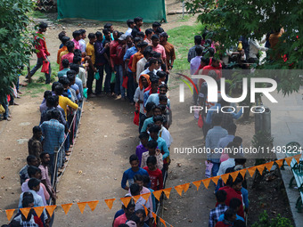 Hindu devotees are waiting in a long queue to pay their obeisance on the occasion of the Raksha Bandhan festival at the Shankaracharya templ...