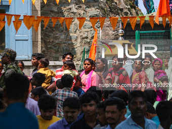 Hindu devotees are waiting in a long queue to pay their obeisance on the occasion of the Raksha Bandhan festival at the Shankaracharya templ...