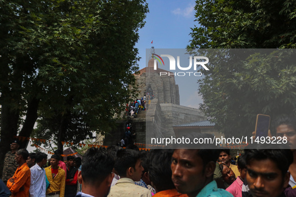 Hindu devotees are waiting in a long queue to pay their obeisance on the occasion of the Raksha Bandhan festival at the Shankaracharya templ...