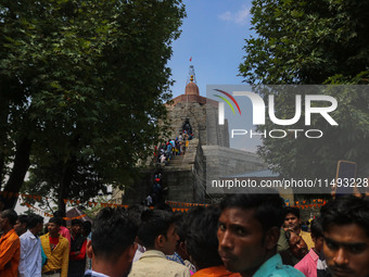 Hindu devotees are waiting in a long queue to pay their obeisance on the occasion of the Raksha Bandhan festival at the Shankaracharya templ...