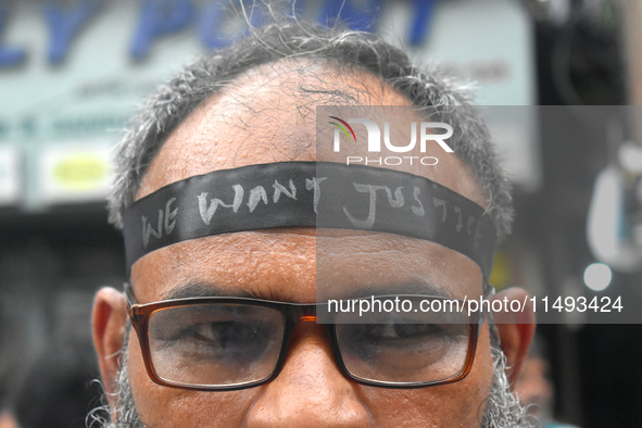 A doctor is tying a black ribbon on his forehead printed with ''we want justice'' during a protest rally for the R G Kar Medical College wom...