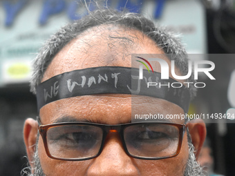 A doctor is tying a black ribbon on his forehead printed with ''we want justice'' during a protest rally for the R G Kar Medical College wom...