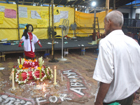 A person is standing in front of a clay statue of a doctor depicting a victim of rape and murder at a protest site in Kolkata, India, on Aug...