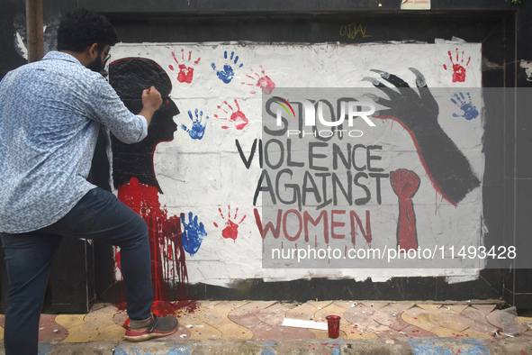 A doctor is painting slogans inside Kolkata Medical College and Hospital campus condemning the rape and murder of a trainee medic at a gover...