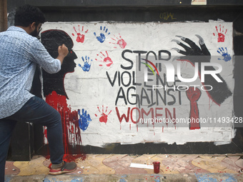 A doctor is painting slogans inside Kolkata Medical College and Hospital campus condemning the rape and murder of a trainee medic at a gover...