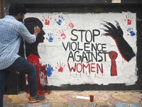 A doctor is painting slogans inside Kolkata Medical College and Hospital campus condemning the rape and murder of a trainee medic at a gover...