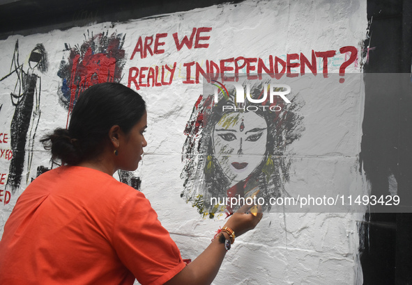 A doctor is painting a mural with slogans inside Kolkata Medical College and Hospital campus condemning the rape and murder of a trainee med...