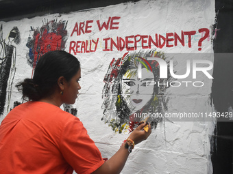 A doctor is painting a mural with slogans inside Kolkata Medical College and Hospital campus condemning the rape and murder of a trainee med...