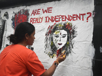 A doctor is painting a mural with slogans inside Kolkata Medical College and Hospital campus condemning the rape and murder of a trainee med...