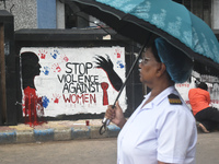 A nurse is passing next to a mural with slogans inside Kolkata Medical College and Hospital campus condemning the rape and murder of a train...