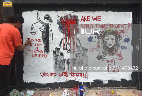 A doctor is painting a mural with slogans inside Kolkata Medical College and Hospital campus condemning the rape and murder of a trainee med...