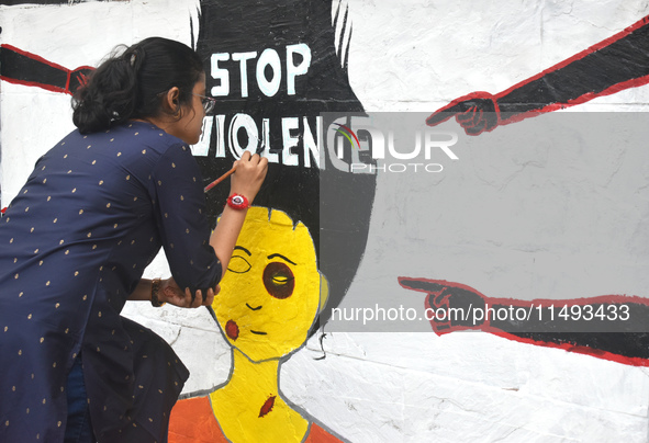 A doctor is painting a mural with slogans inside Kolkata Medical College and Hospital campus condemning the rape and murder of a trainee med...