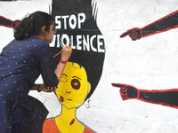 A doctor is painting a mural with slogans inside Kolkata Medical College and Hospital campus condemning the rape and murder of a trainee med...